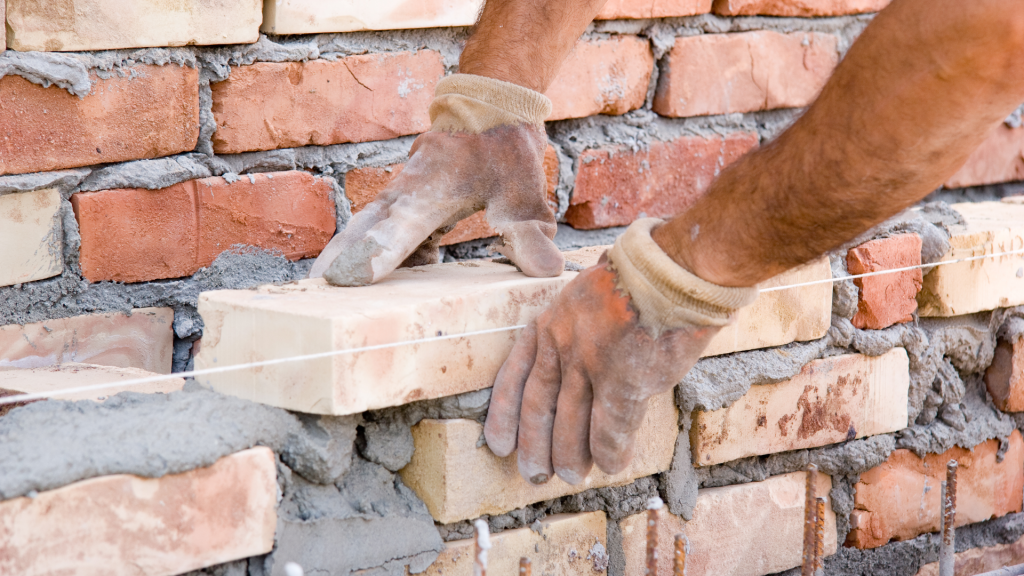 Un ouvrier en train de poser des briques.