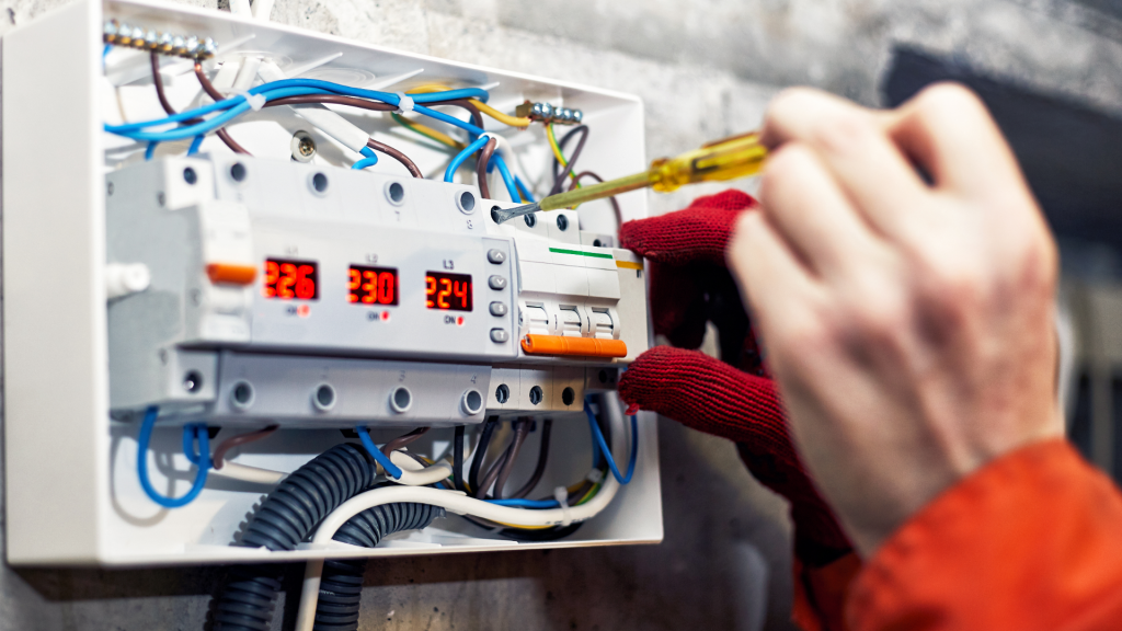 Un ouvrier en train de placer un bloc électrique.